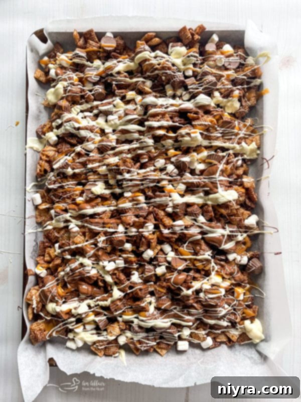 Melted caramel being drizzled over the Chex Mix