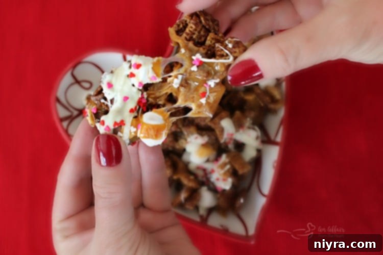 Close-up of Better Than Sex Chex Mix, with a piece being pulled