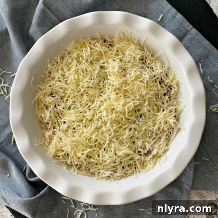 Prepping Impossible Pie with Bacon Swiss: layering bacon, green onions, and Swiss cheese