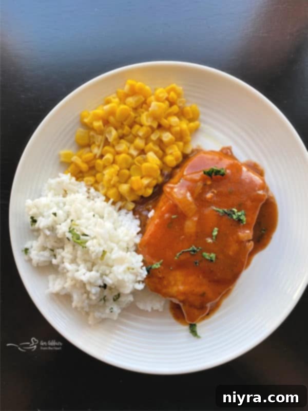 Plated Taco Pork Chops served alongside vibrant cilantro lime rice and sweet corn, a complete meal.
