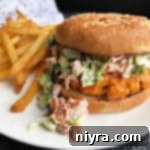 Blackened Salmon Burgers and BLT Slaw 15 Blackened Salmon Burgers with BLT Slaw with fries on white plate