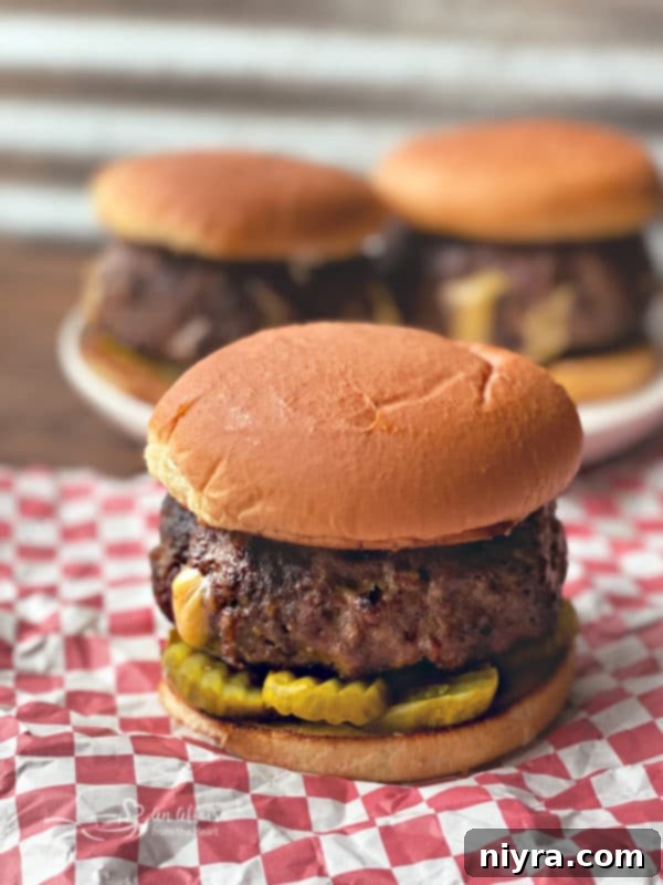 A perfectly grilled Juicy Lucy burger, showing off its golden-brown bun and a hint of the cheesy interior.