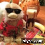 Dirty monkey cocktail with a stuffed monkey, a banana and a book on a table with text 