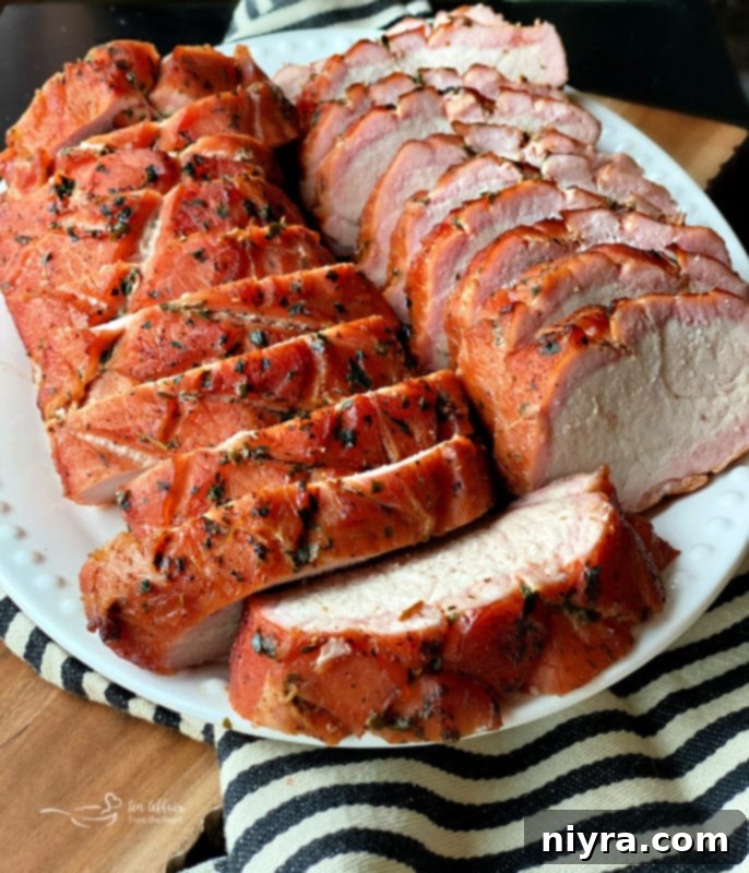 Succulent Smoked Pork Loin 3 Perfectly sliced smoked pork loin showing a prominent smoke ring, served on a white plate