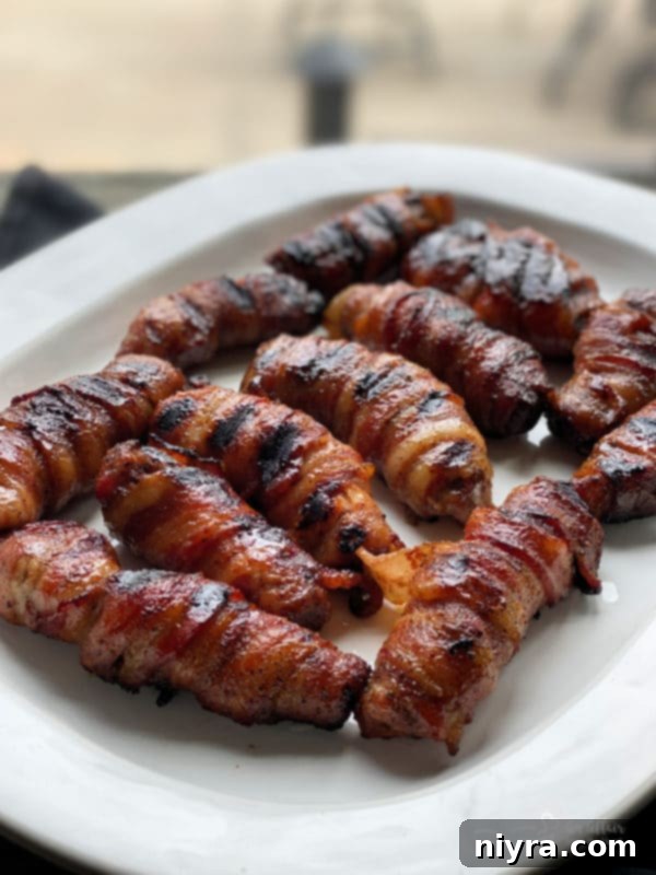 Sweet and Spicy Bacon Wrapped Pork Ribs plated, garnished with fresh herbs.