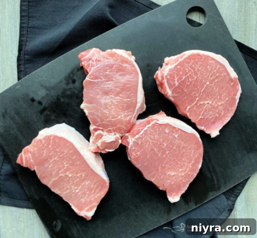 Raw pork loin chops on a cutting board, an alternative to country style ribs.