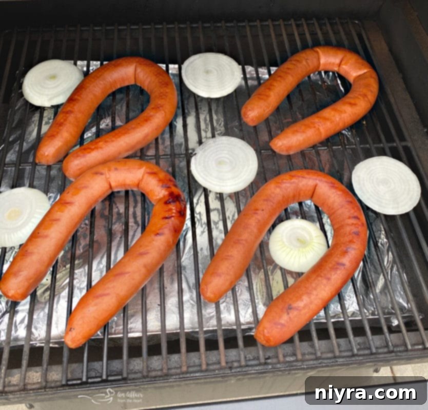 Sliced onions grilling on a barbecue grate with tongs, getting a smoky char