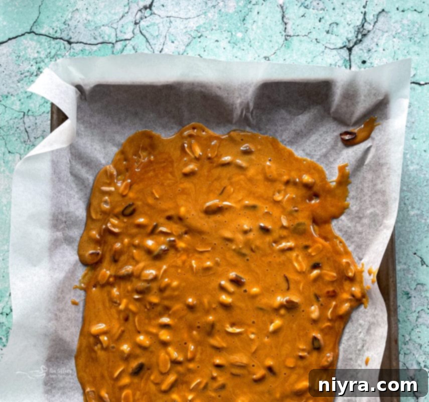 Pouring hot peanut brittle mixture onto baking sheets
