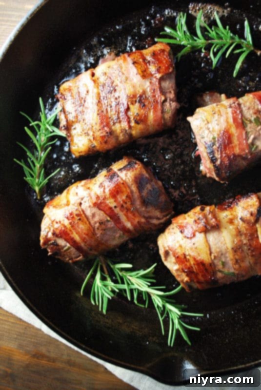 A beautifully cooked venison tenderloin, wrapped in bacon and sliced for serving.