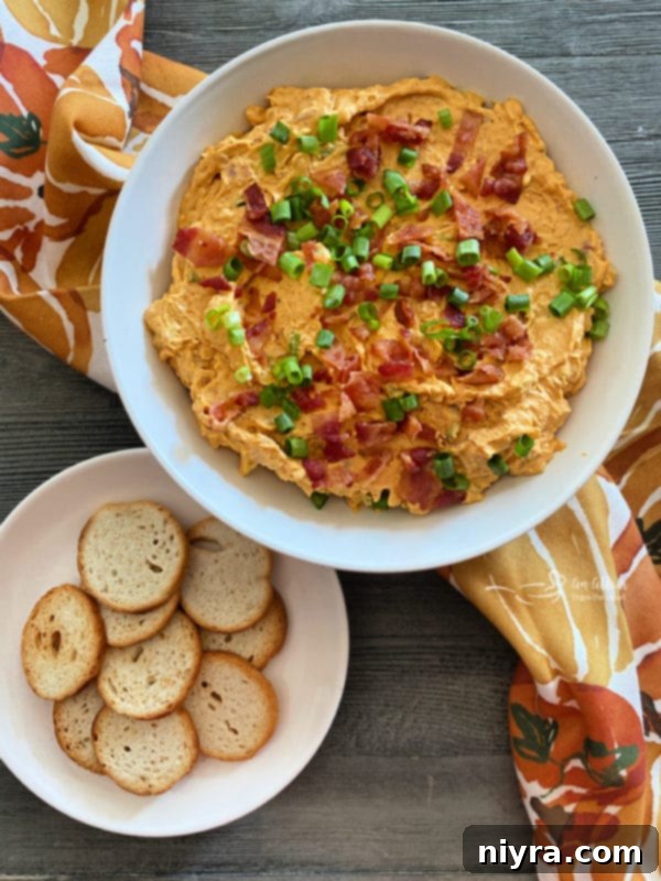 Smoky Bacon & Creamy Pumpkin Cheese Dip 7 Savory Pumpkin Cheese Dip with Bacon in a serving bowl, garnished