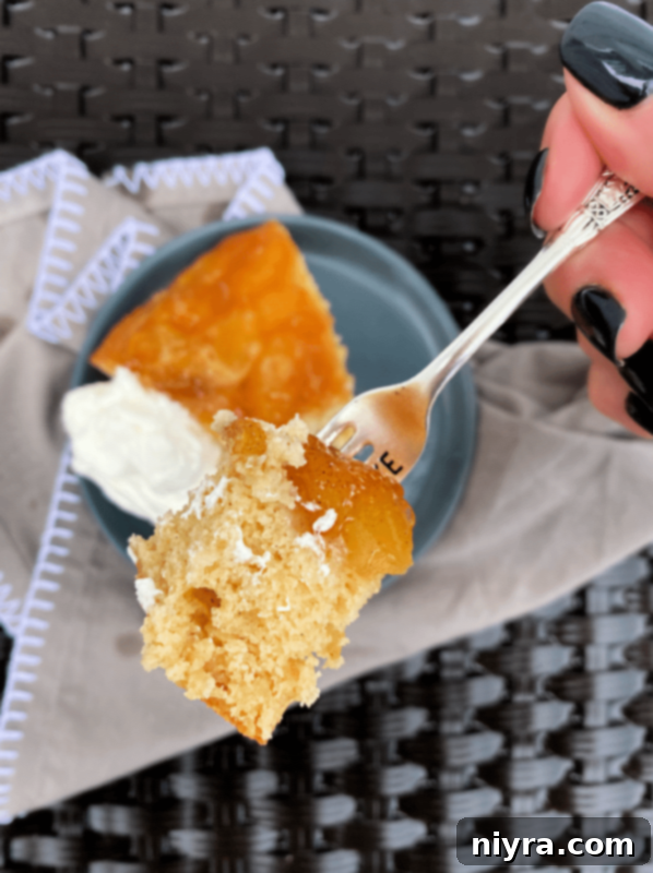 Caramel Apple Flip Cake 5 A fork taking a bite from a slice of Apple Upside Down Cake
