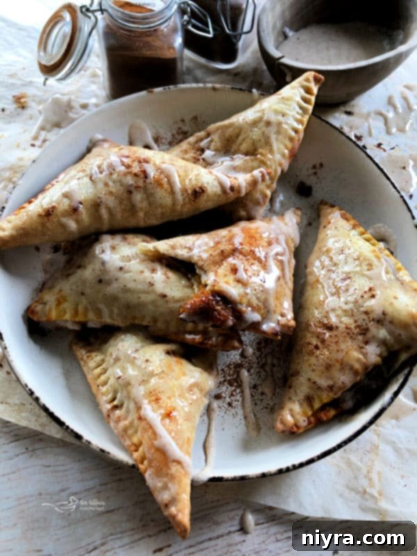 Golden brown pumpkin pie turnovers on a white plate