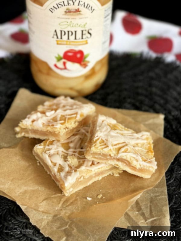 Stack of Apple Bars with a jar of Paisley Farm Sliced Apples, highlighting the convenience