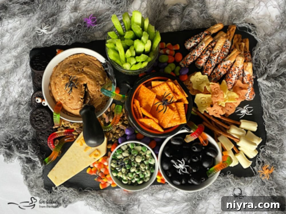 Spooky Sweet and Savory Halloween Snack Board with Peanut Butter Dip 2 A vibrant Halloween snack board filled with a variety of sweet and savory treats, centered around a bowl of peanut butter dip.