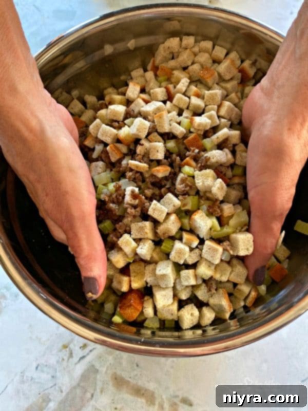 Preparing Mom's Sausage & Sage Dressing: Mixing ingredients by hand
