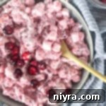 Close up of Cranberry Fluff Salad in bowl with light bluish background