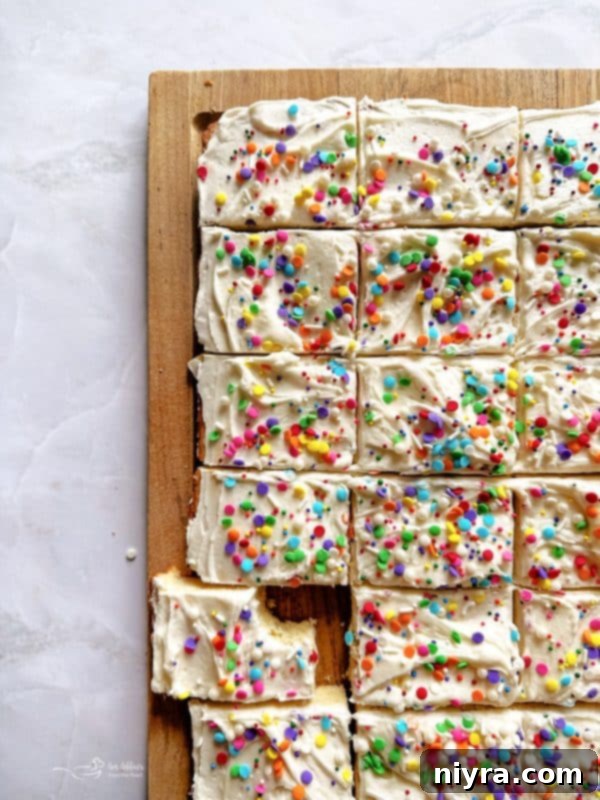 Frosted Sugar Cookie Bars with pink frosting and sprinkles