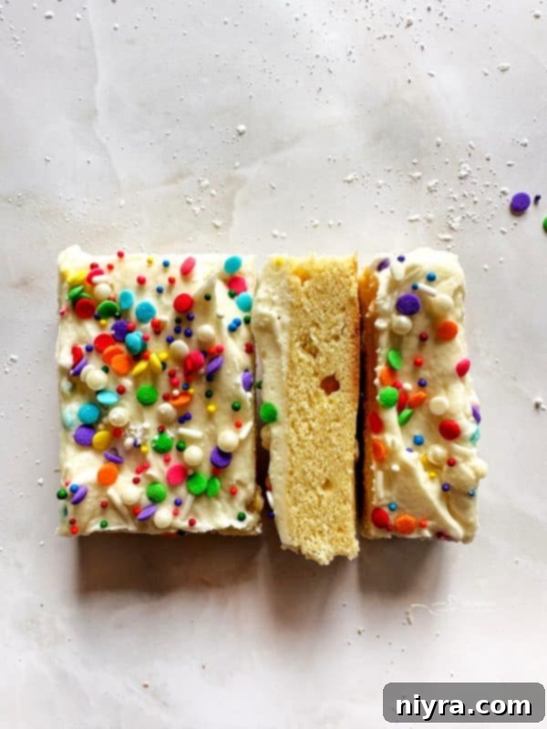 Stacked frosted sugar cookie bars with sprinkles.