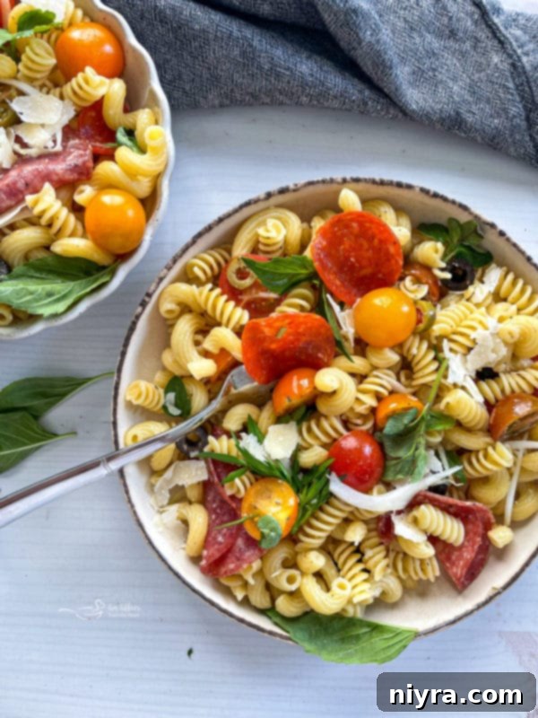 Italian Deli Pasta Salad 3 Two bowls of pasta salad with tomatoes and pepperoni