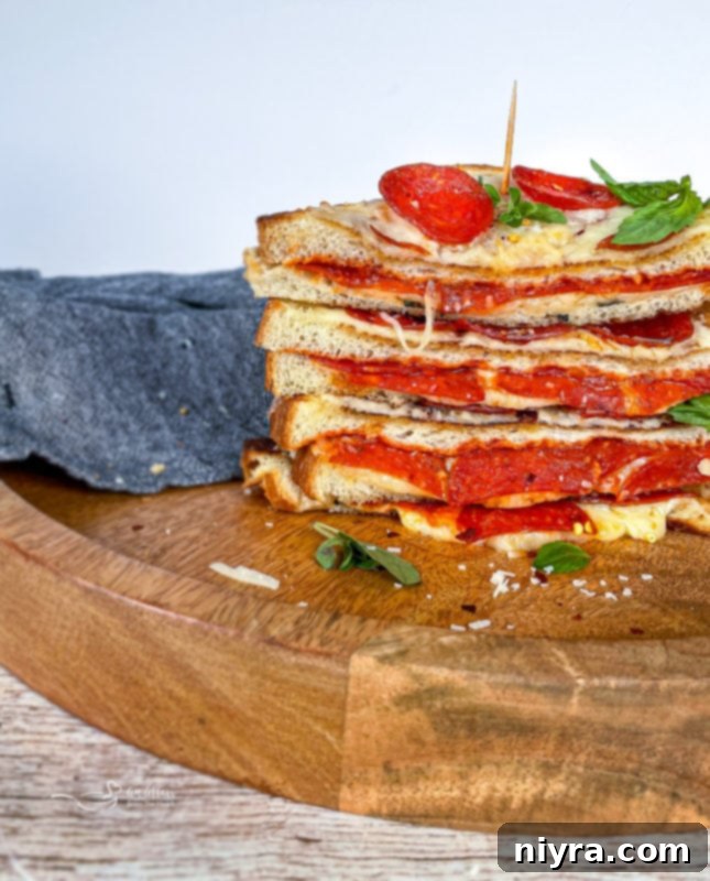 Pepperoni pizza grilled cheese sliced in half, showing gooey melted cheese