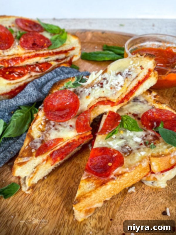 Close-up of a pepperoni pizza grilled cheese, showing the melted cheese and crispy pepperoni