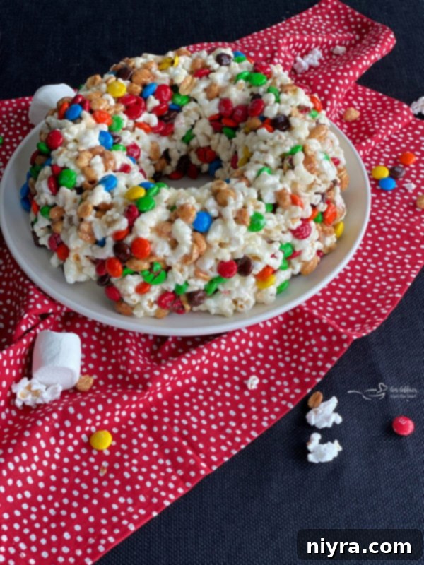 Close-up of a slice of Popcorn Cake showing the gooey marshmallow and colorful M&M's.