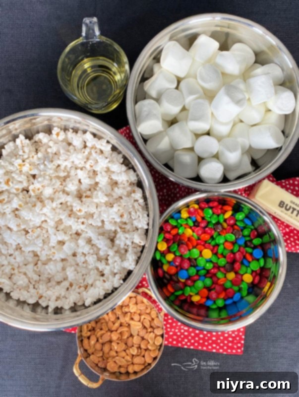 Ingredients for Popcorn Cake: popcorn, marshmallows, butter, oil, M&M's, and peanuts.