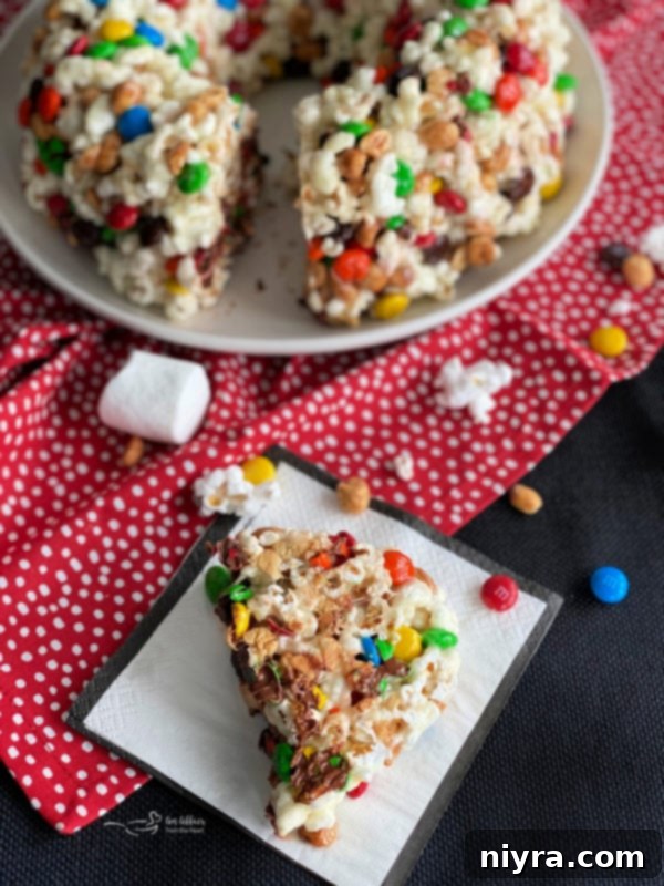 Popcorn Cake on a stand with a slice removed, revealing the interior.