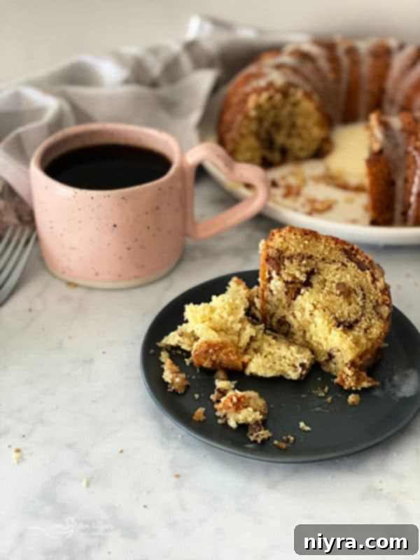 Whole Sour Cream Coffee Cake with glaze on a serving stand