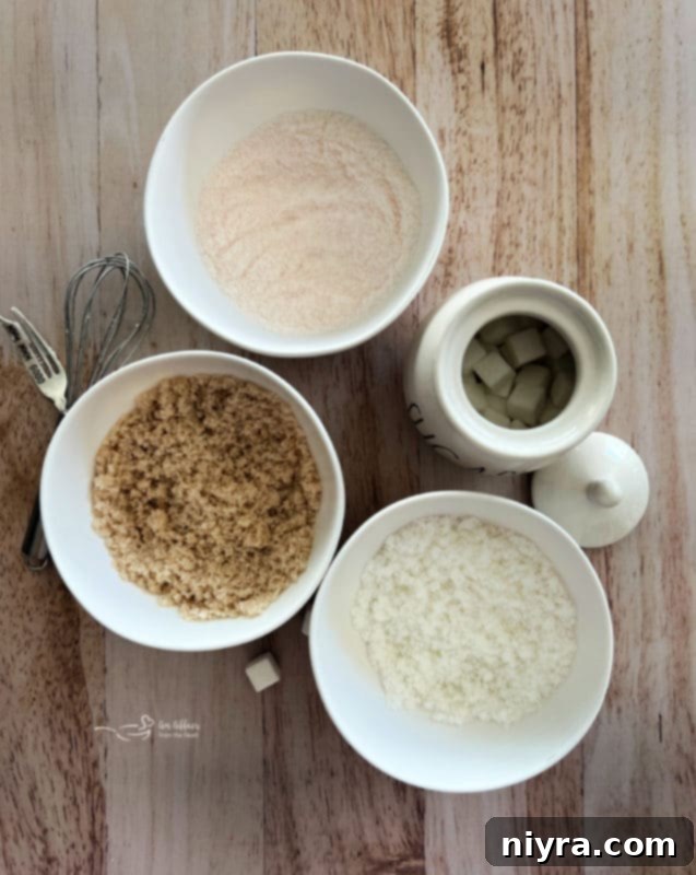 A close-up of a small bowl of granulated sugar, with a measuring spoon drizzling liquid extract onto it.