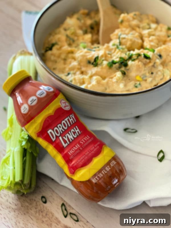 Closeup of chopped hard-boiled eggs and celery being added to cooked potatoes for potato salad.