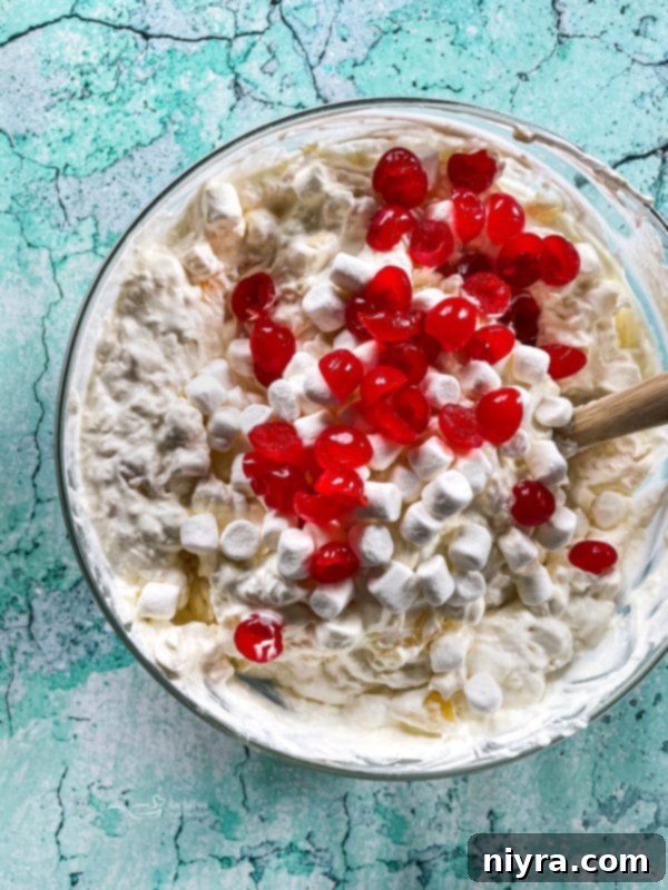 The combined piña colada fluff mixture in a large white bowl, before adding the final fruits.
