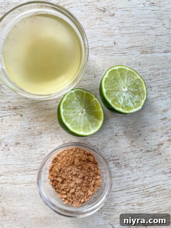 Close-up shot of fresh lime juice, whole limes, and a packet of taco seasoning, highlighting the key flavor components for the slow cooker pork.