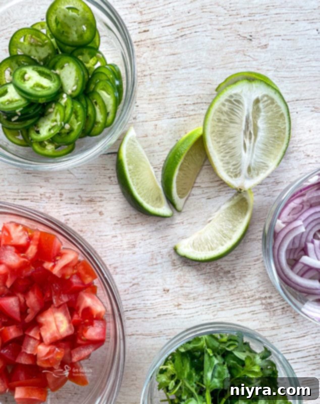 An array of fresh toppings: vibrant tomatoes, fresh cilantro, fiery jalapeños, zesty lime wedges, and crisp red onions, perfect for garnishing the slow cooker pork.