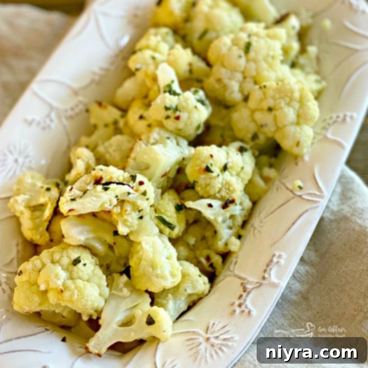 Crispy Roasted Cauliflower 3 Square image of seasoned raw cauliflower florets on a baking sheet before roasting.