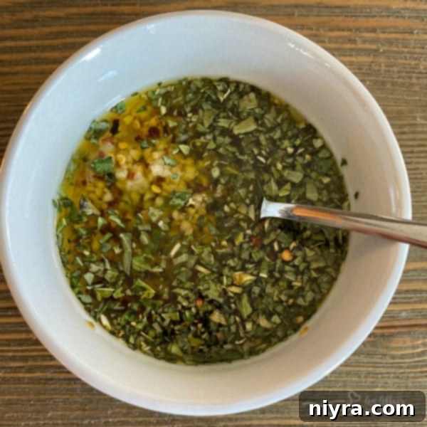 Crispy Roasted Cauliflower 5 Olive oil being drizzled over seasoned cauliflower florets in a Ziploc bag.