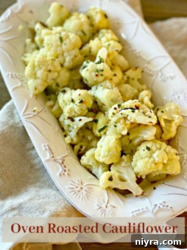 Crispy Roasted Cauliflower 9 Oven roasted cauliflower served as a side dish in a white bowl, garnished with fresh herbs. Main hero image.