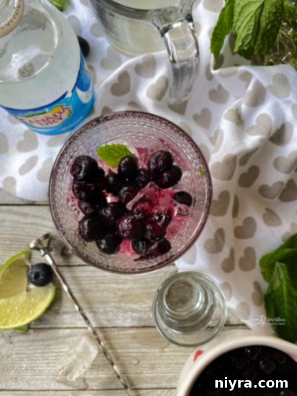 Adding ice, lime juice, and rum to a Blueberry Mojito