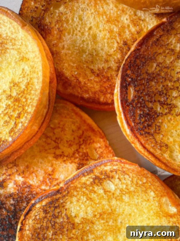 Burger buns being toasted on a griddle, showing the golden-brown interior