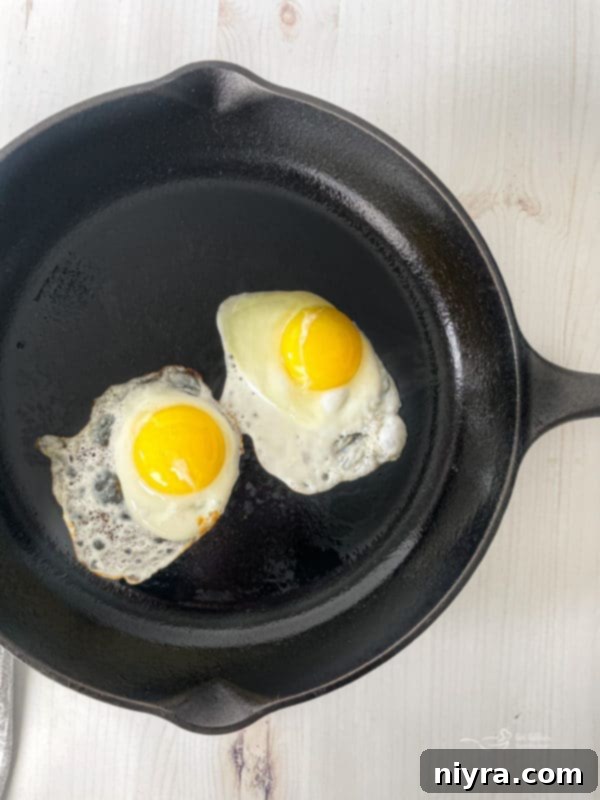 A single fried egg, perfectly cooked and ready to top a Hangover Burger