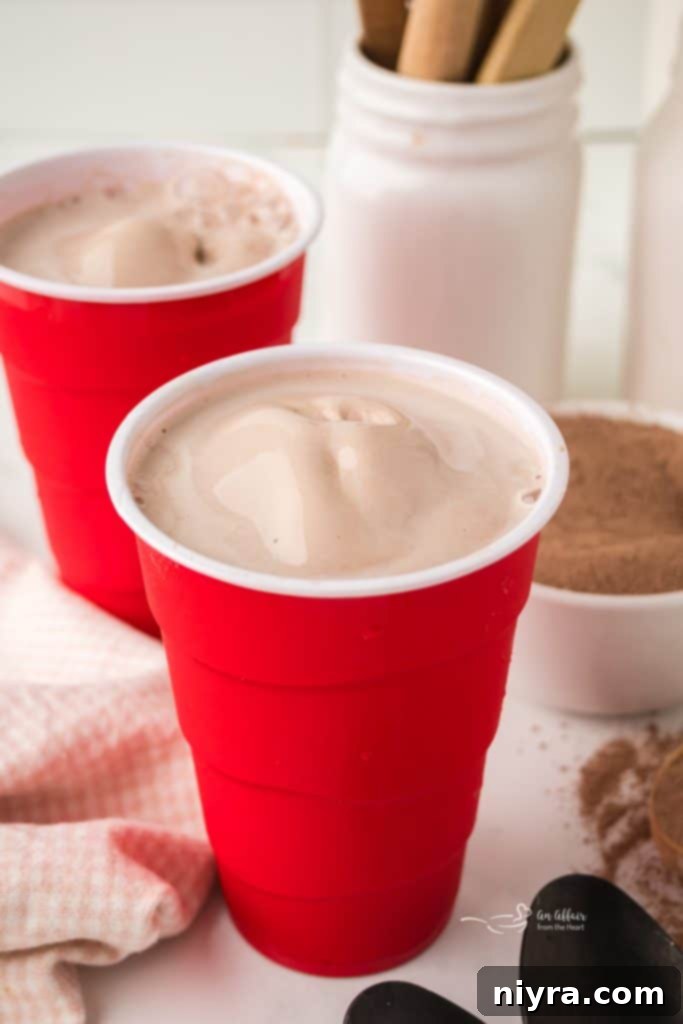 A glass of homemade Wendy's Frosty with a spoon, showcasing its rich texture.