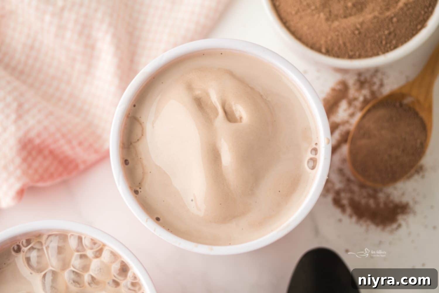 A close-up shot of a glass of homemade Frosty with various ingredients in the background.