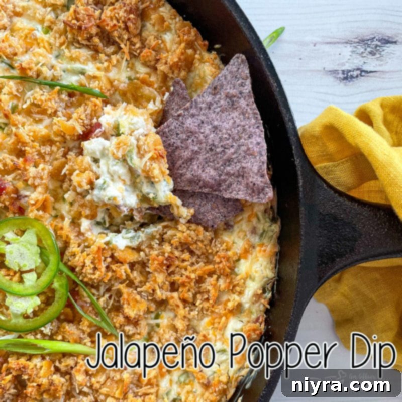 Baked Jalapeño Popper Dip 13 top view of jalapeño popper dip with chip in skillet