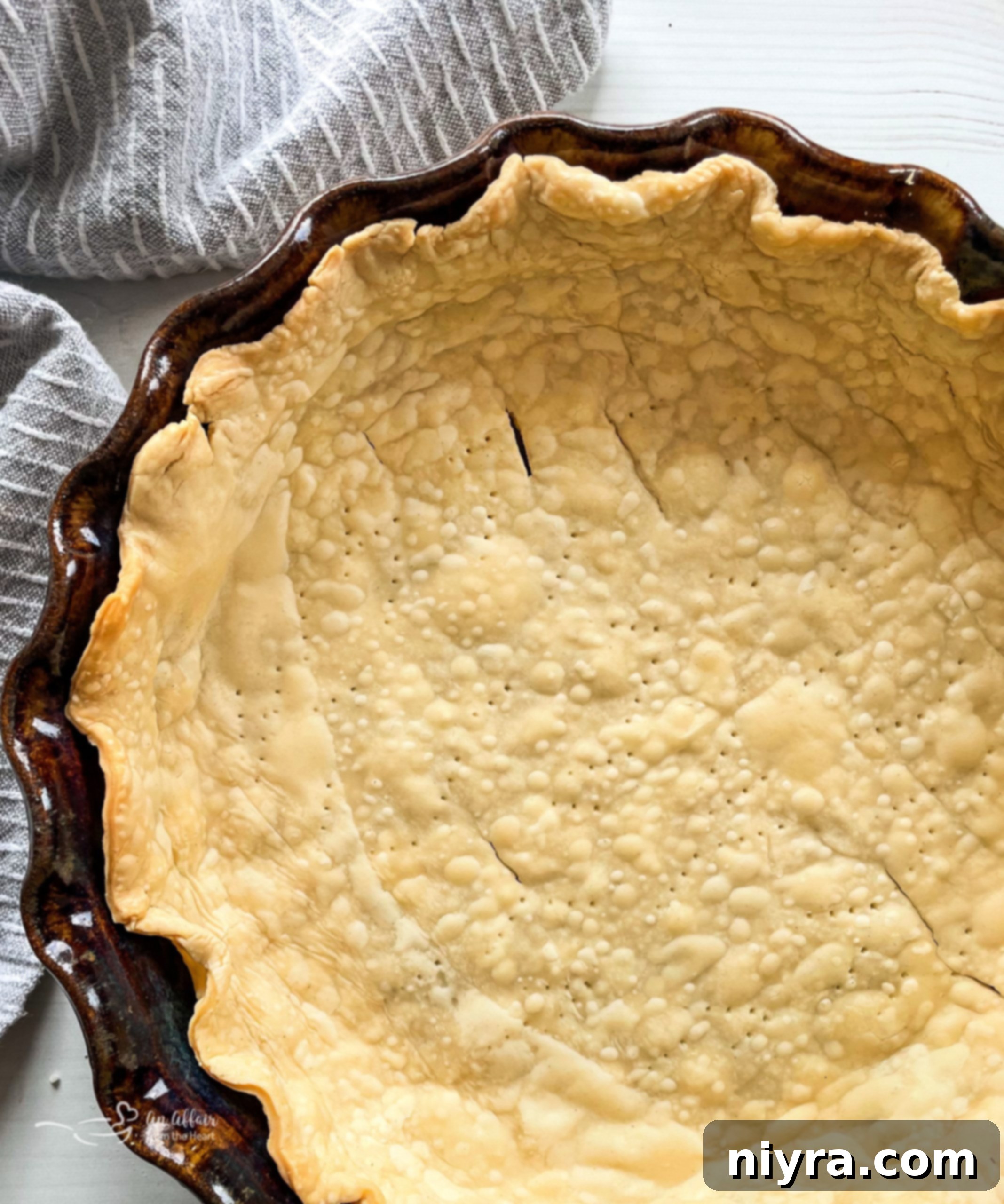 Homemade pie crust in a metal pie tin, ready for blind baking or filling.