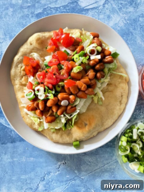 Native American Fry Bread Tacos 2 Indian Tacos in fry bread, white plate, blue background