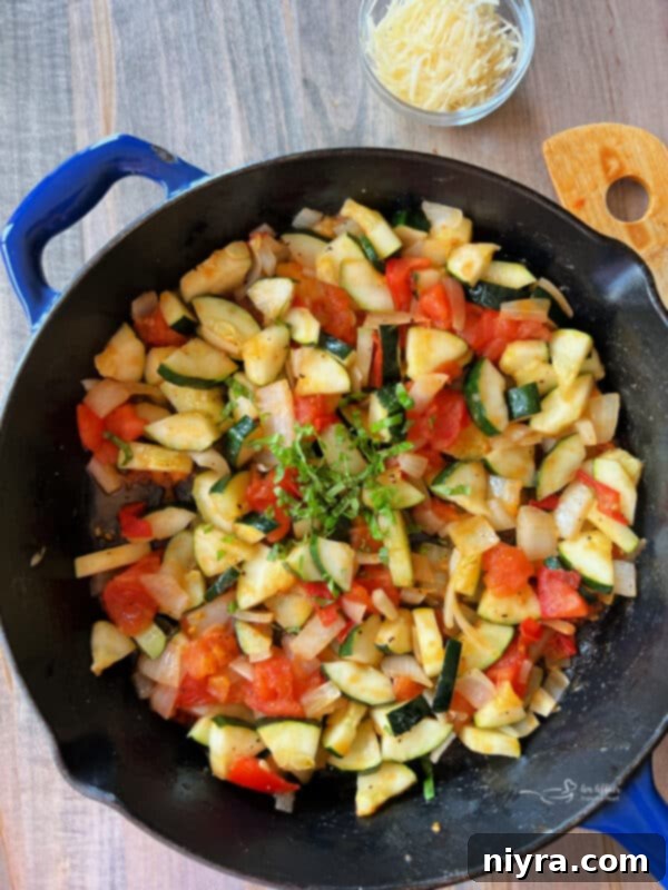 Sauteed zucchini and tomatoes reaching desired tenderness