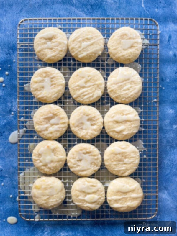 Applying lemon glaze to cookies with a spoon