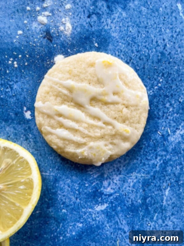 Lemon glaze being drizzled from a piping bag over cookies