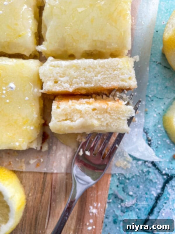 Lemon brownies on a fork with a delicate lemon glaze