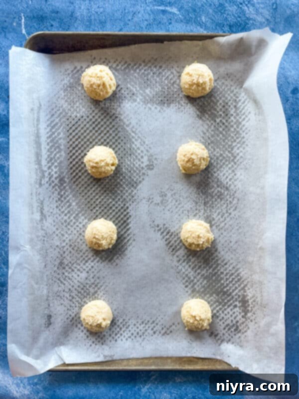 Scooping cookie dough onto a parchment-lined baking sheet